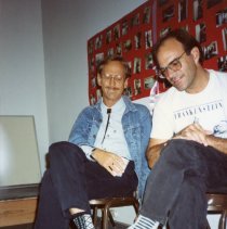 Two men sit together at potluck