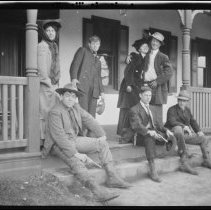 Group of two women and five men on a porch