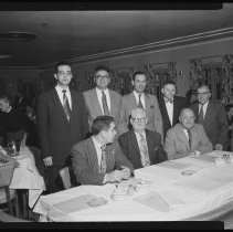 Eight men at banquet table
