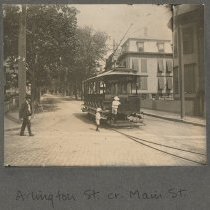 A man and two children walk towards and board the streetcar at Arlington St