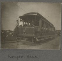 Four young women and men posing at the front of parked Hampton Beach (N.H.)