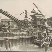 Cement mixer and conveyor at construction site of Merrimack River retaining