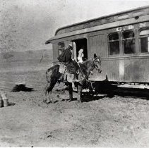 Woman on horseback next to California and Nevada Railroad car
