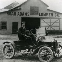 Noah Adams in his automobile in front of his lumber company