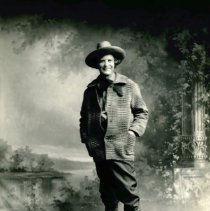 Elbert Hubbard standing in hat and coat.