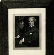Elbert Hubbard wearing pinstripe suit seated.