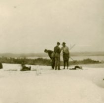 Men shell hunting on a frozen lake.