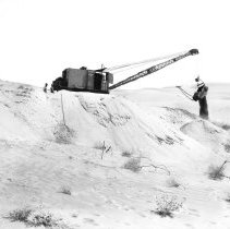 Construction of highway through sand dunes. Dredge moving sand.