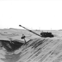 Construction of highway through sand dunes. Dredge moving sand.