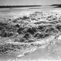 Close up view, looking downstream, of water coming through the spillway of