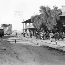 Group of people at Yuma Railroad Depot. Tracks lead off to the Ocean to Oce