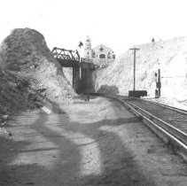 View of railroad tracks in Yuma. Indian Mission on hill above tracks.