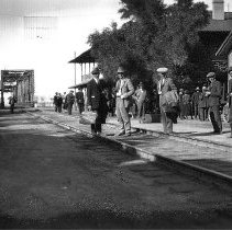 Group of people at Yuma Railroad Depot. Tracks lead off to the Ocean to Oce