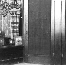 Entrance to Hetzel's Photo Shop showing door and window display.