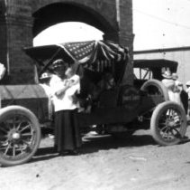 Mrs. Hetzel holding her daughter by the family car. Her son is sitting in t