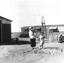 Mrs. Hetzel with her children standing in front of a building that sold dri