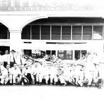 Group portrait of El Centro Lion Club members in front of a Gilmour car whi