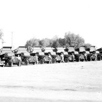Group of men standing in front of Griffin Bros. dump trucks. Front view.