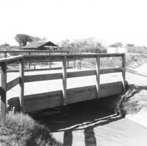 Holton Power Canal - Holtville. Wooden bridge over canal with building in b