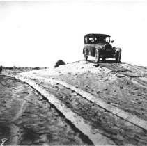 Two track Plank Road in sanddunes with a Peerless Eight on the tracks.