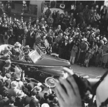 Desert Cavalcade parade. Two men and one women riding in car with a police