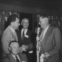 Senator Ben Hulse shaking hands with Richard Nixon at a banquet.