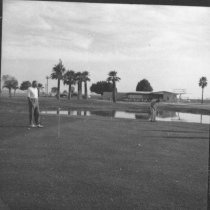 Barbara Worth County Club - Men golfing, club building in background.