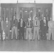 Group of Law Enforcement officers standing in front of a trophy case