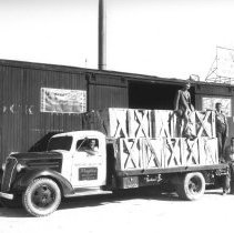 Whiting Mead Co. delivery truck parked next to a railroad box car.