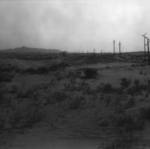 Distance view of dragline digging new highway road through sand dunes.