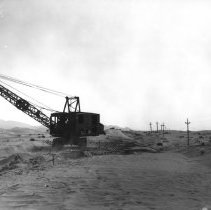 Close up view of dragline digging new highway road through sand dunes.