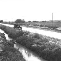 Leo Hetzel's auto parked on a dirt road next to a canal.