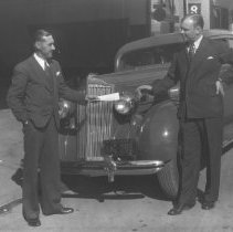 Men standing in front of a Packard 120 car.