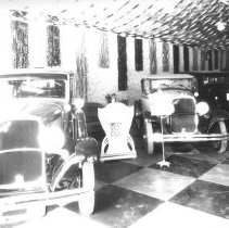 Interior of Inland Motor Car Co. - showroom with De Soto cars on display.