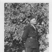 Claude Ritter standing in front of a citrus tree wearing his American Legio