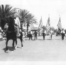 Elmer Heald riding a horse in a parade in front of a color guard. Calexico