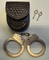 Metal handcuffs with black leather case and keys, c. 1963-1993