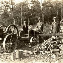 men cutting wood using pulley powere saw