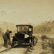 car and man driving on old rxr tracks