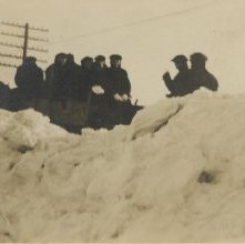 crew shoveling snowbound electric car