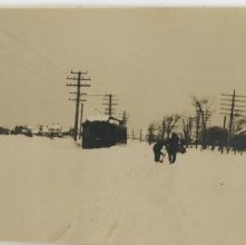 crew shoveling snowbound electric car