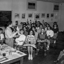 Bancroft junior high school activities.  Boy showing model doll in class.