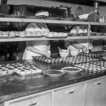 Bancroft junior high school activities.  Cafeteria.  Putting cup cakes in pans.