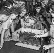 Irving junior high school activities.  Students discussing with social science teacher the arrangement of a typical municipal courtroom.  (Model made by the WPA)