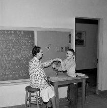 Washington Boulevard school, Elementary activities. Teacher helping a child use a bit.