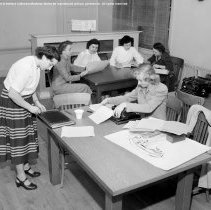 Pupils, teachers and student teachers in typical classroom situations.  Taken at Nora Sterry school. [Teachers copying and reviewing papers.]