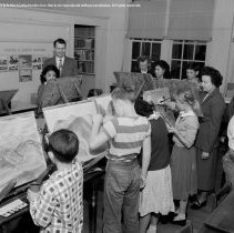 Pupils, teachers and student teachers in typical classroom situations.  Taken at Nora Sterry school. [Students painting on easels, art class.]