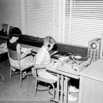 Class activities at Bellagio Road Elementary School.  Students and teachers are shown using the library facilities, music instruction, using audio visual equipment, playing musical instruments, and art.
