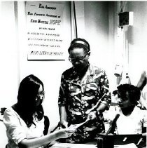 Lois Hofstra, secretary, admits a young patient to ship's hospital