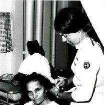 HOPE Nurse Judy Slemmons combing the hair of a lady patient.